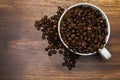 Cup full of coffee beans over wooden background Royalty Free Stock Photo