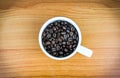Cup full of coffee beans on wood desk Royalty Free Stock Photo