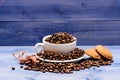 Cup full coffee brown roasted bean blue wooden background. Cafe drinks menu. Coffee break with oat cookie. Fresh roasted Royalty Free Stock Photo