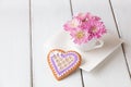 Cup full of pink mum flowers and heart shape cookie on white w Royalty Free Stock Photo