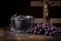 A cup of grape juice with wooden cross and metal Barbed Wire made like the crown of thorns of Jesus on wooden