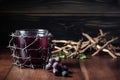 A cup of grape juice with wooden cross and metal Barbed Wire made like the crown of thorns of Jesus on wooden