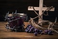 A cup of grape juice with wooden cross and metal Barbed Wire made like the crown of thorns of Jesus on wooden