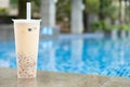 a cup of grass jelly near a swimming pool at horizontal composition Royalty Free Stock Photo