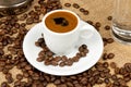 Cup of Greek coffee on sack background with coffee beans. Turkish coffee in white small mug. Royalty Free Stock Photo