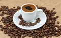 Cup of Greek coffee on sack background with coffee beans. Turkish coffee in white small mug. Royalty Free Stock Photo
