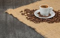 Cup of Greek coffee on sack background with coffee beans. Turkish coffee in white small mug. Traditional Greek coffee Royalty Free Stock Photo
