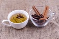 A cup of green tea with anise and a cup of coffee beans with cinnamon sticks Royalty Free Stock Photo