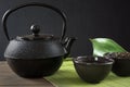Cup with green tea with black china kettle on black with copy space. Close up. Chinese tea concept. Royalty Free Stock Photo