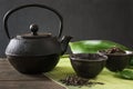 Cup with green tea with black china kettle on black with copy space. Close up. Chinese tea concept Royalty Free Stock Photo