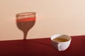 A cup of green tea casts the shadow of a glass of wine. The concept of waiting for the evening in the morning