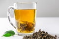 A Cup of green tea with dried large leaf tea and fresh tea leaves on a white background. Diet and healthy drink Royalty Free Stock Photo