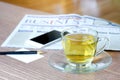 Cup of green tea hot on the desk has a newspaper and a tablet. at office Royalty Free Stock Photo