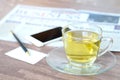 Cup of green tea hot on the desk has a newspaper and a tablet. at office Royalty Free Stock Photo