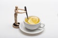 Cup of green tea and humanlike toy stirring it. Royalty Free Stock Photo