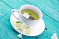 Cup of green tea with jasmine flowers on turquoise rustic wooden Royalty Free Stock Photo