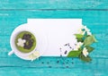 Cup of green tea with jasmine flowers on turquoise rustic wooden Royalty Free Stock Photo