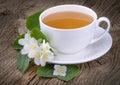 Cup of green tea with jasmine flowers on wooden background Royalty Free Stock Photo