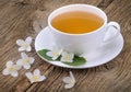 Cup of green tea with jasmine flowers on wooden background Royalty Free Stock Photo