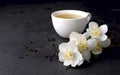 Cup of green tea and Jasmine flowers on a black background. Herbal medicine Royalty Free Stock Photo