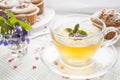 Cup of green tea with lemon balm and tasty muffins with sugar hearts Royalty Free Stock Photo