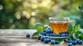 a cup of green tea next to blueberry on a wooden table. blurred background of summer garden from behind Royalty Free Stock Photo