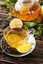 Cup with green tea and teapot on the brown wooden background Royalty Free Stock Photo