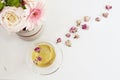 A cup of healthy herbal tea with dried roses. Beautiful fresh flowers on light marble table, top view. Pink roses and gerberas on Royalty Free Stock Photo