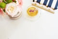 A cup of healthy herbal tea with dried roses. Beautiful fresh flowers, notebooks on light marble table, top view. Pink roses and g