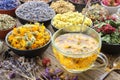 Cup of healthy marigold tea and calendula flowers. Healthy calendula tea poured into glass cup. Medicinal herbs on background Royalty Free Stock Photo