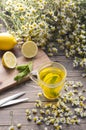 A cup of herbal chamomile tea with camomile blossoms, lemons and mint leaves. The concept of alternative medicine and immune boost Royalty Free Stock Photo