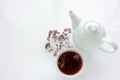 Cup of herbal oregano tea with dry marjoram flowers on white table background with copy space.