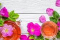 Cup of herbal rose hip tea with teapot over white wooden background