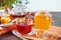 Cup of herbal tea with flowers, honey in jar, teapot and and various dried herbs on the tray. Royalty Free Stock Photo