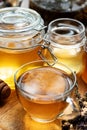 cup of herbal tea with golden fresh natural linden honey in glass jar at wooden tray in beautiful sunny light. close up Royalty Free Stock Photo