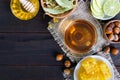 A cup of herbal tea, honey, honeycomb, hazelnuts on a dark wooden background