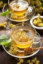 Cup of herbal tea with linden flowers on old wooden table Royalty Free Stock Photo