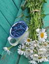 Cup with honeyberry and daisy flowers vertical Royalty Free Stock Photo