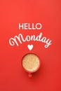Cup of hot aromatic coffee and phrase Hello Monday on red background, top view