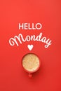 Cup of hot aromatic coffee and phrase Hello Monday on red background, top view Royalty Free Stock Photo