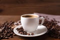 Cup of hot aromatic coffee and roasted beans on wooden table, closeup Royalty Free Stock Photo