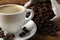 Cup of hot aromatic coffee and roasted beans on wooden table, closeup. Space for text Royalty Free Stock Photo