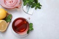 Cup of hot aromatic tea with mint and lemon on light grey table, flat lay. Space for text Royalty Free Stock Photo