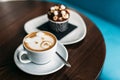 Cup of hot bear latte art coffee with delicious cupcake Royalty Free Stock Photo