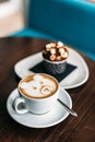 Cup of hot bear latte art coffee with delicious cupcake Royalty Free Stock Photo