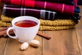 Cup of hot berry tea Pile of woolen clothes on wooden background Autumn winter food concept Tea Nut Blanket Scarf Cinnamon Copy sp