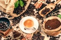 Cup of hot black coffee with old wooden mill grinder and burlap