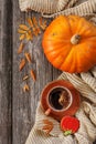 Cup of hot black coffee and pumpkin shaped gingerbread with autumnal leaves, pumpkin and warm scarf. Autumn and Halloween