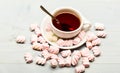 Cup with hot black tea and marshmallows. Cup and sweets prepared as dessert. Mug filled with black brewed tea, spoon and Royalty Free Stock Photo