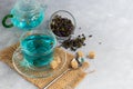 A cup of hot, blue tea with pea flowers. Blue peas. For healthy drinking, detoxifying the body. Gray background Royalty Free Stock Photo